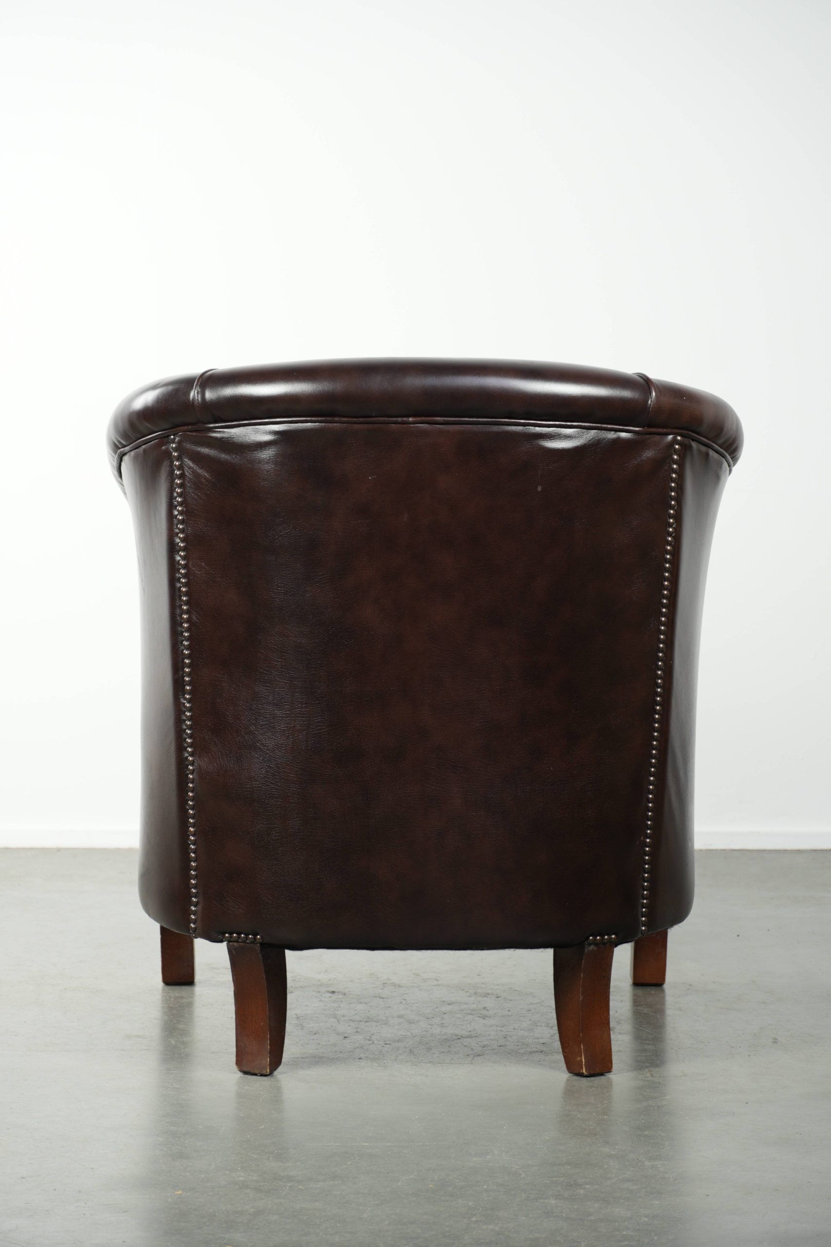 Dark cow leather club armchair in good condition with an English design