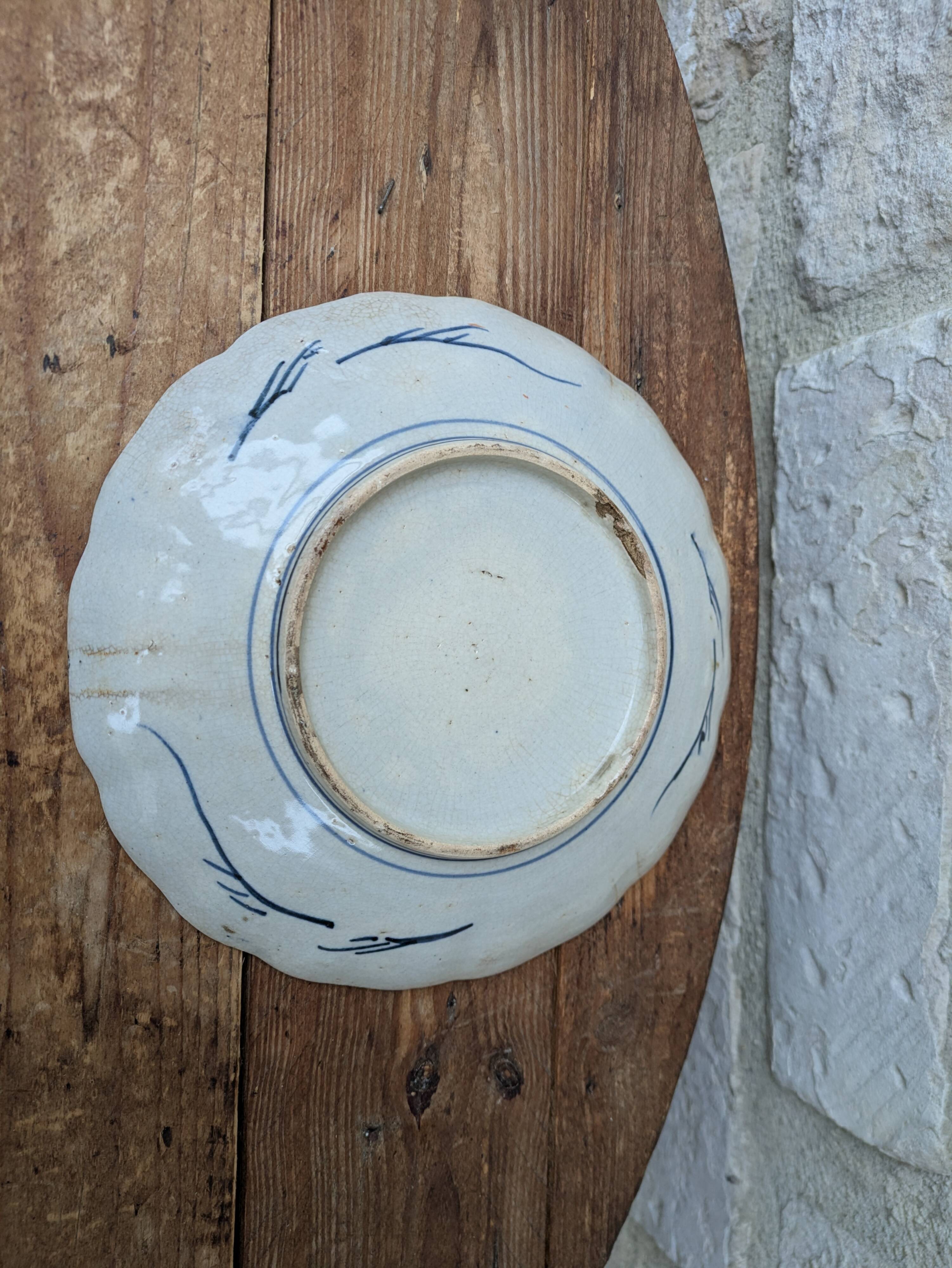 Antique Imari deep plate with red and blue floral decoration, 21.5cm.