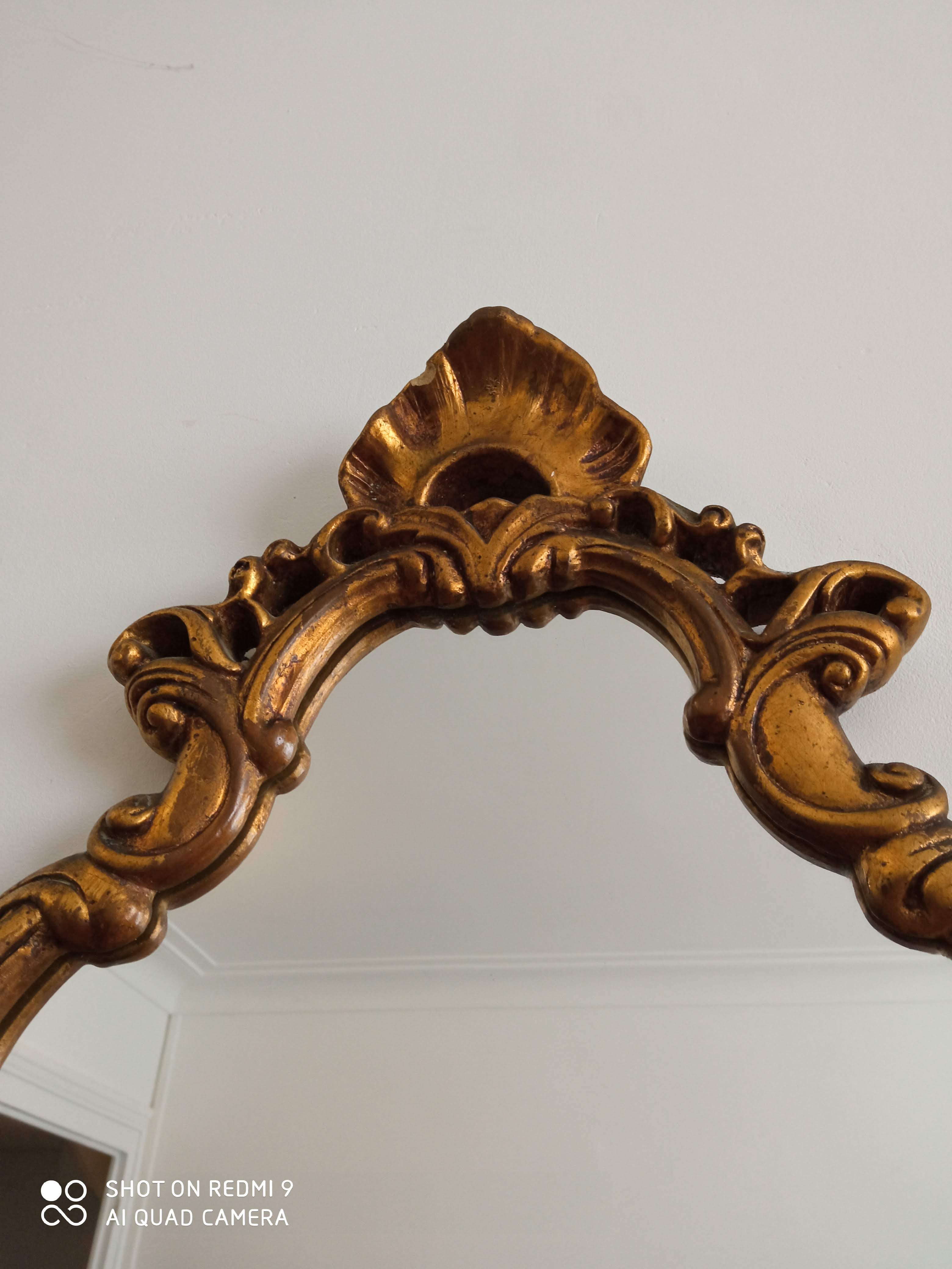 Old wooden mirror and gilded stucco