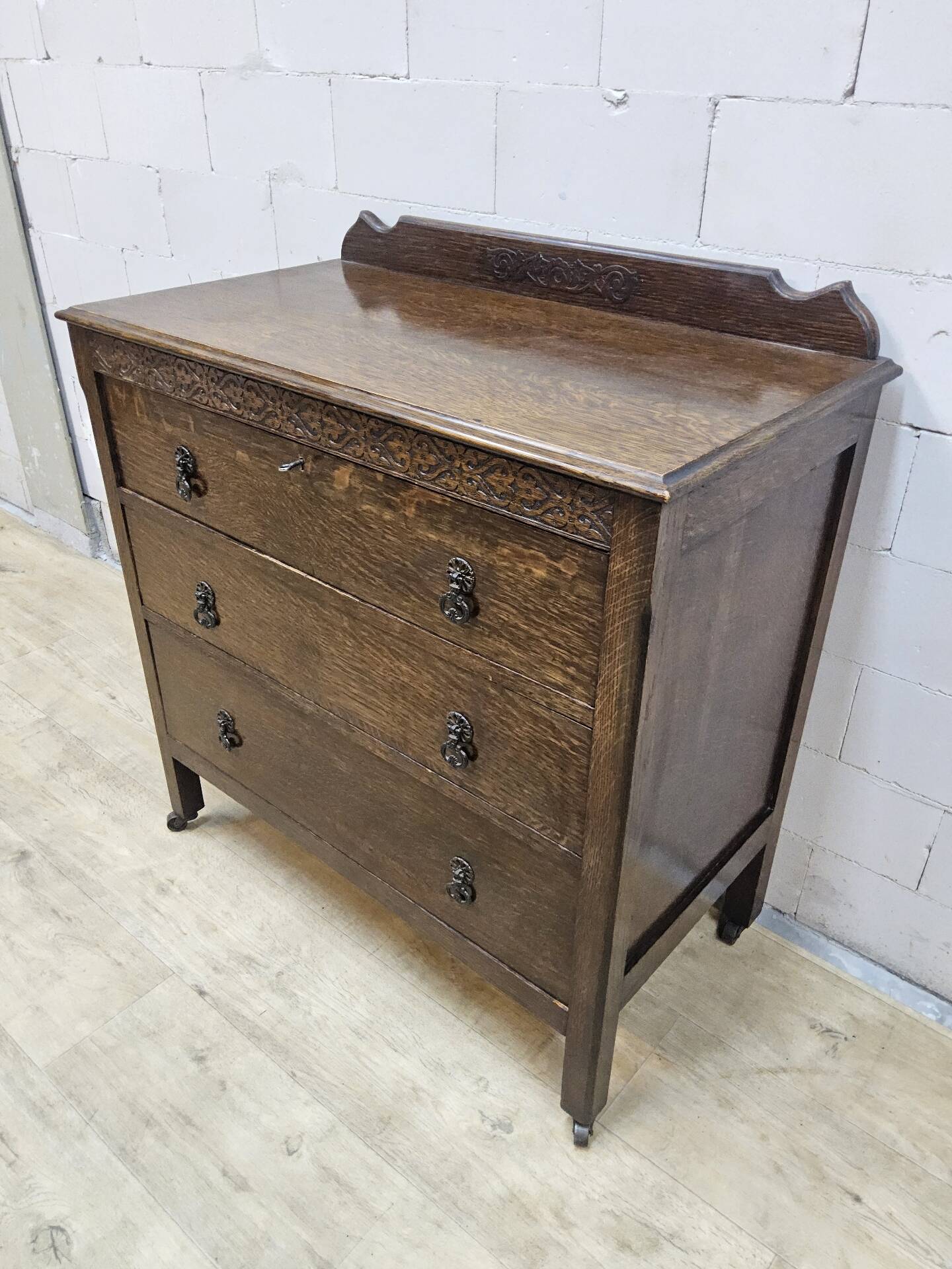 Antique chest of drawers on wheels with wood carving (key top drawer)