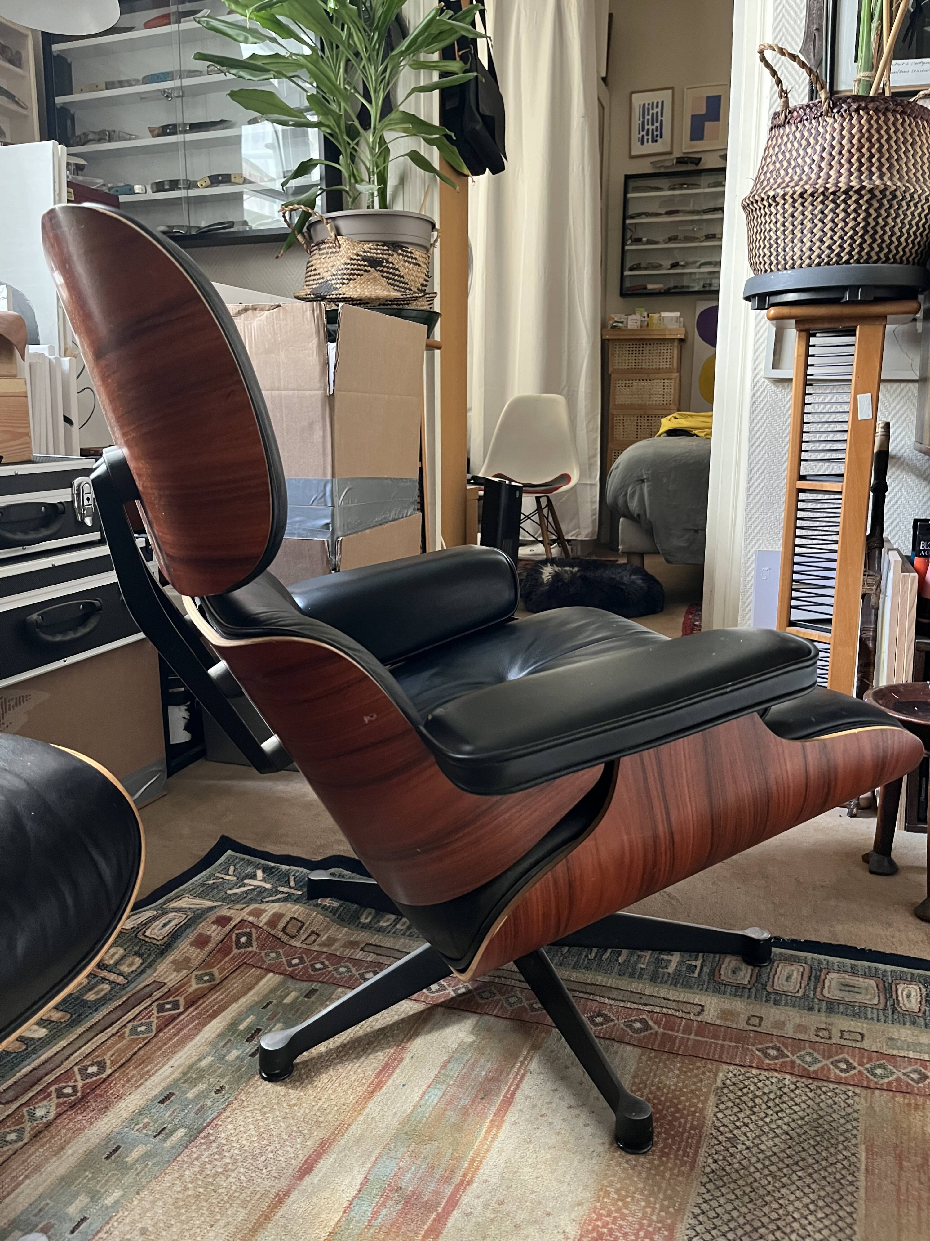 Black leather Eames Vitra armchair, original with rosewood ottoman.