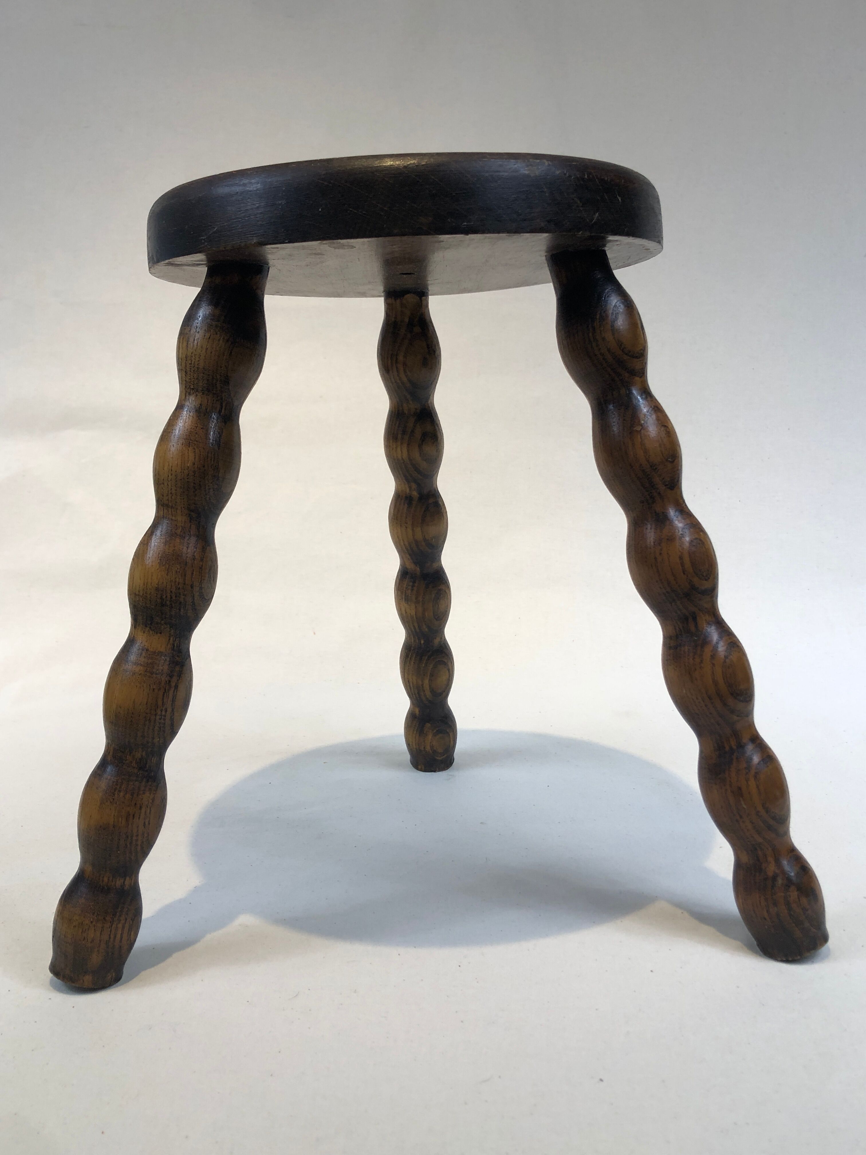 Dark turned wood tripod stool