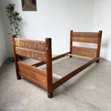 Brutalist style bed with chain and straw