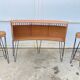Vintage 1950s bar counter with its two rattan and metal stools.