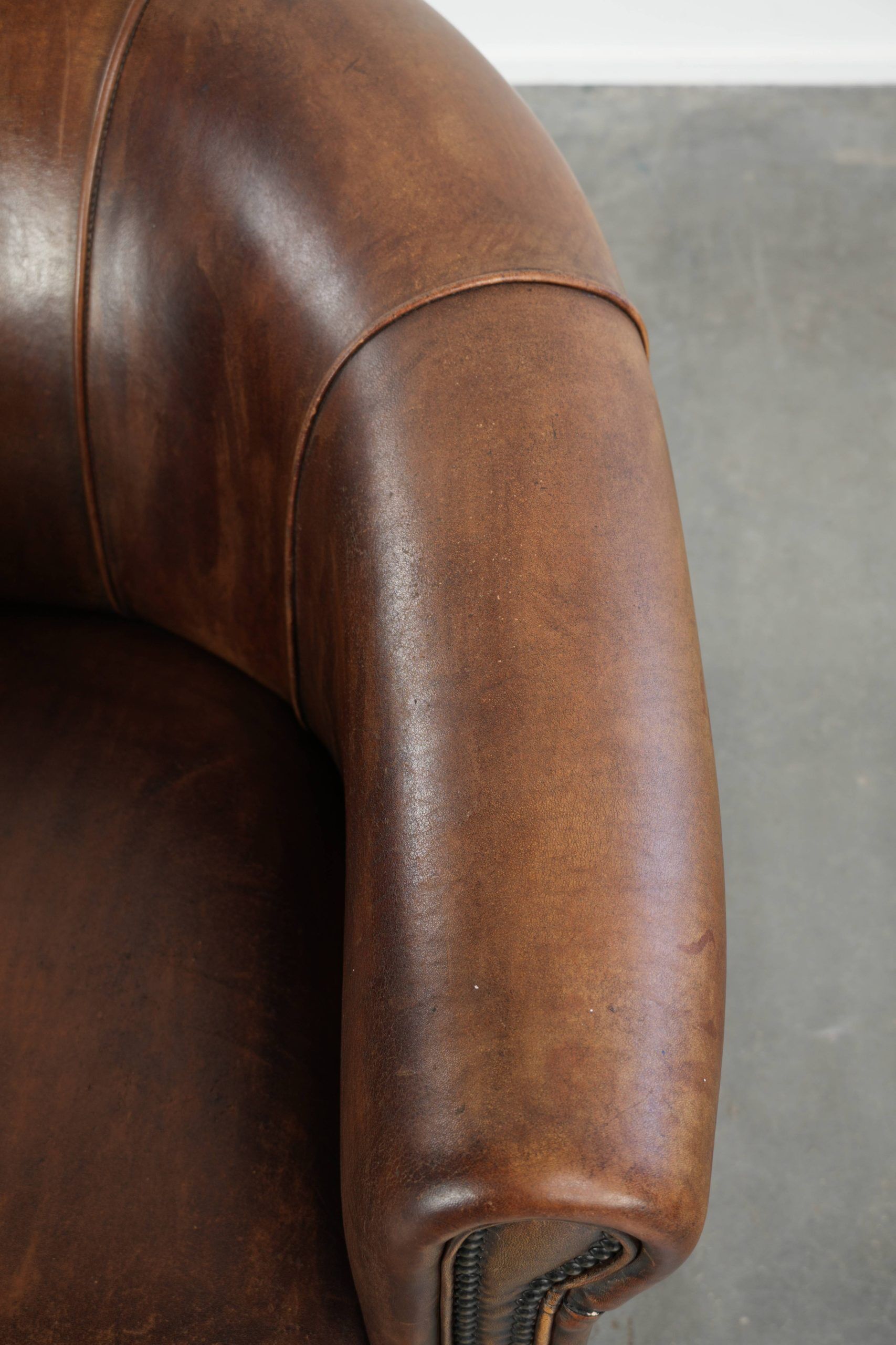 Sheepskin clubarmchair with beautiful patina finished with decorative nails
