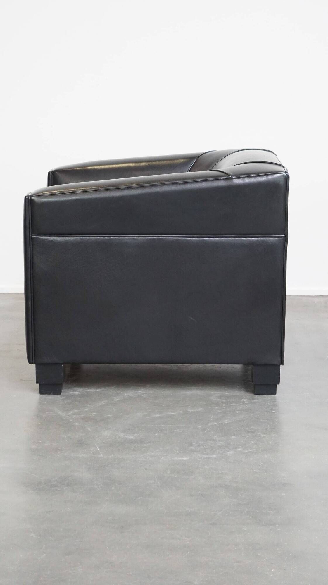 Very comfortable black Art Deco design armchair, made of sheepskin leather