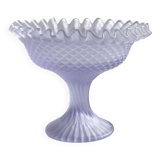 Purple glass pedestal bowl with wavy border and relief pattern.