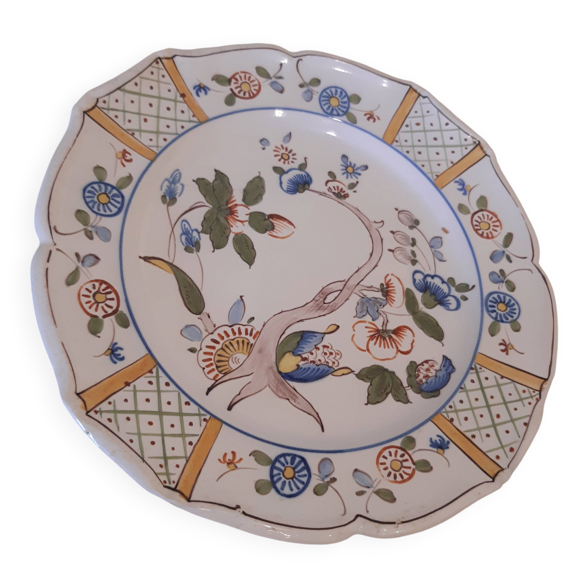 Flat plate in earthenware, hand-painted rural decoration partly in relief,