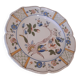 Flat plate in earthenware, hand-painted rural decoration partly in relief,