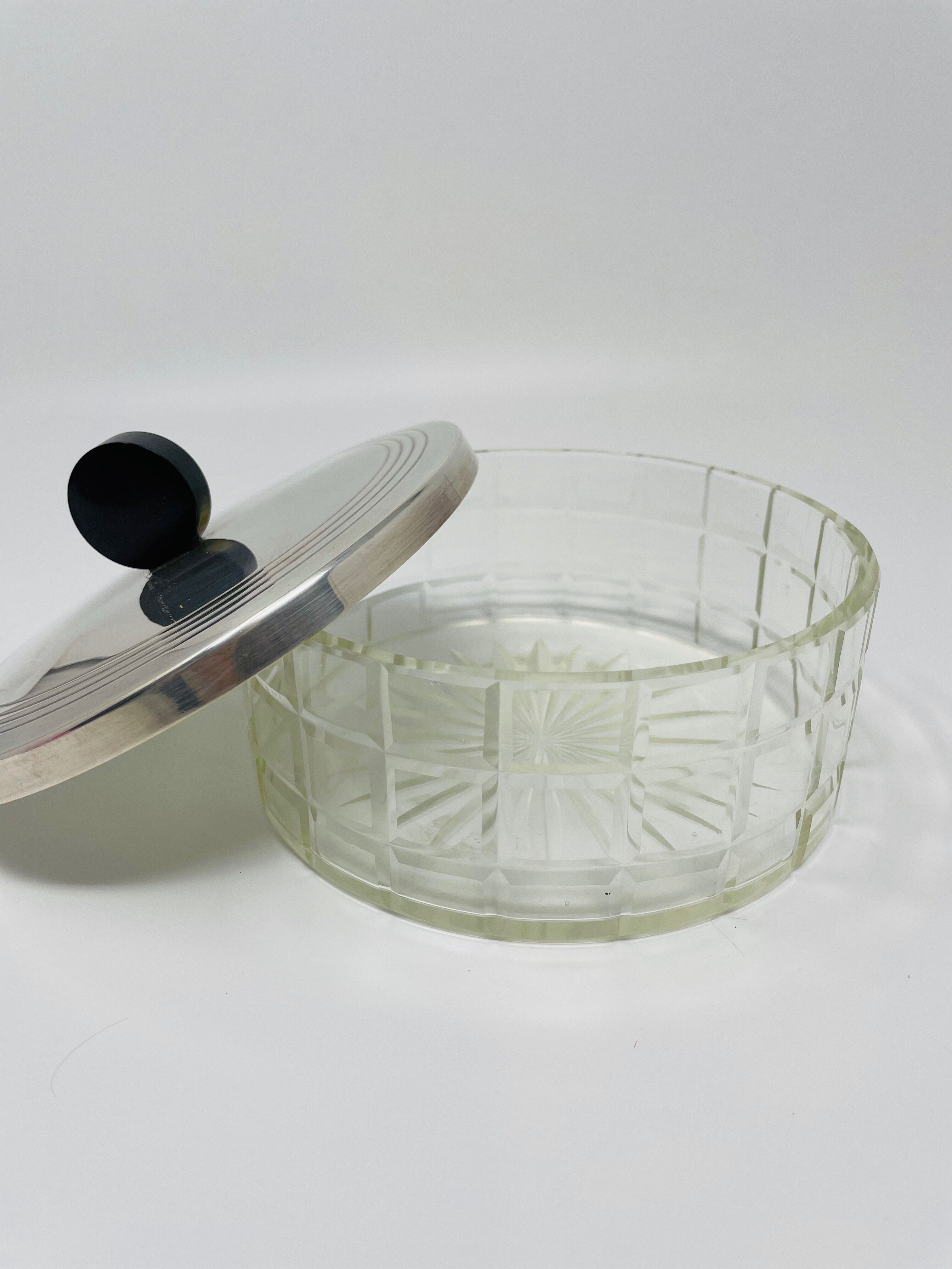 Vintage box made of chiseled glass and covered metal, taken in black Bakelite