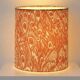 Lampshade covered with a decorative translucent fabric featuring a peacock pattern.