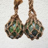 Old glass fishing float with rope net