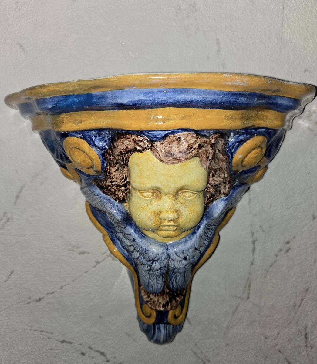 Wall console in glazed ceramic with putto decoration.