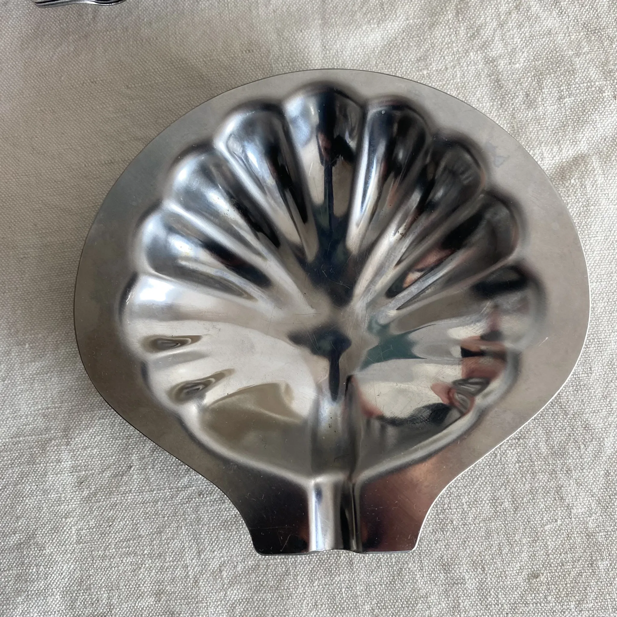 Set of 12 stainless steel scallop shells, 1970s-80s.