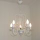 Chandelier vintage en métal blanc à 5 lumières avec des fleurs de glycine roses.