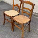 2 solid oak carved and rush-seated chairs in the Louis Philippe style, 19th century.