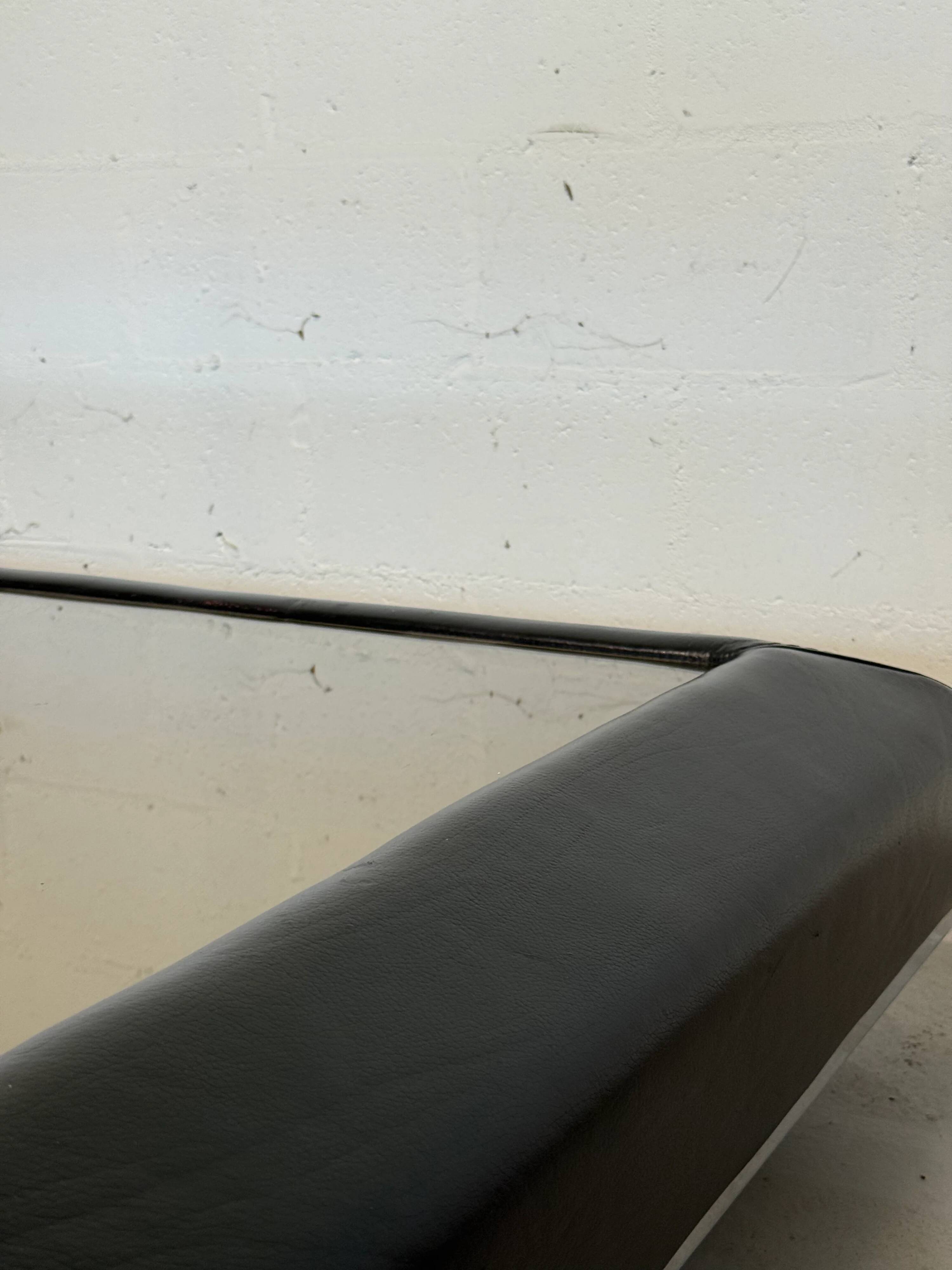 Vintage coffee table covered in leather, smoked mirror top and chrome legs.