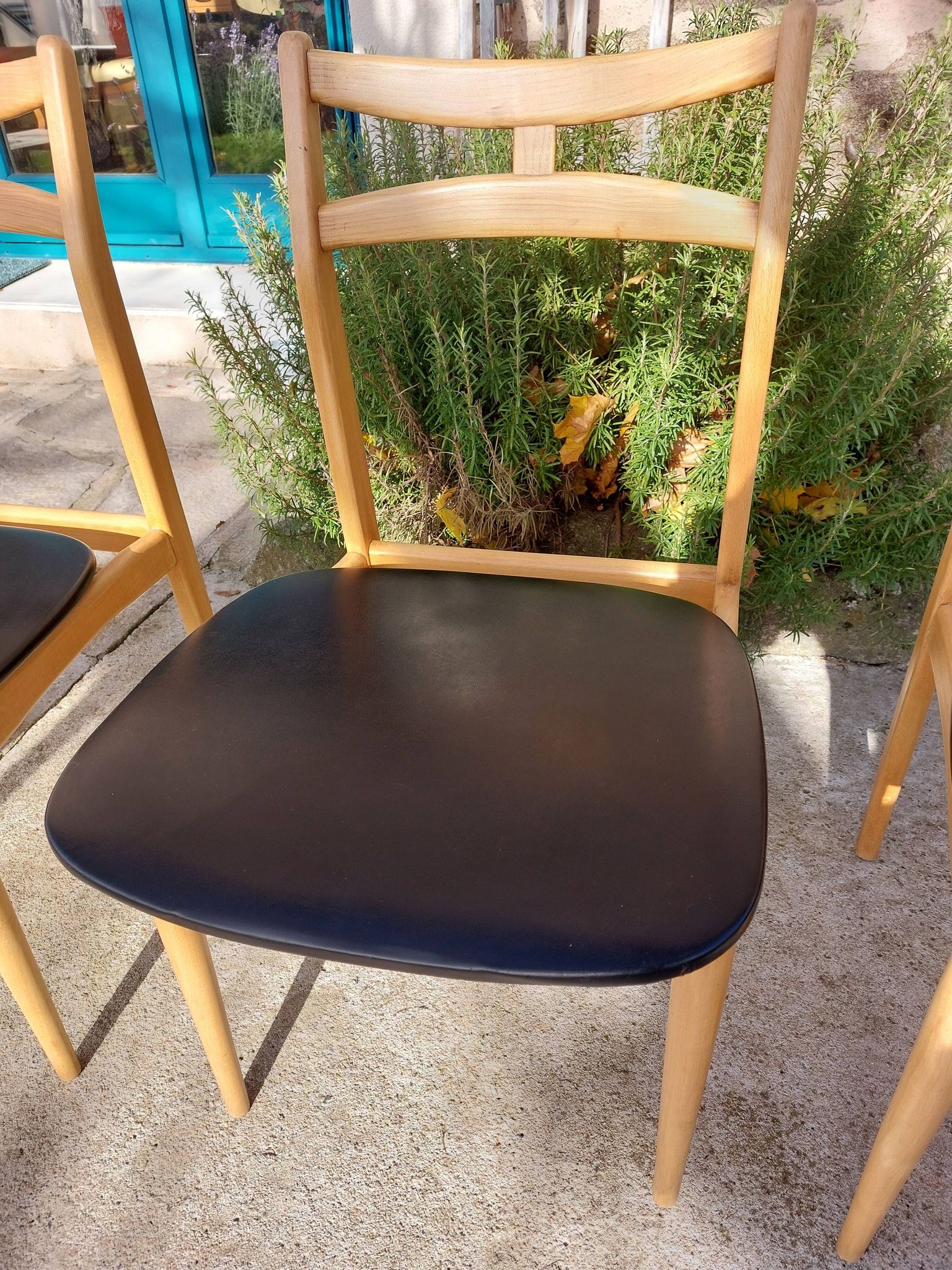3 Scandinavian style chairs, light wood and black faux leather.