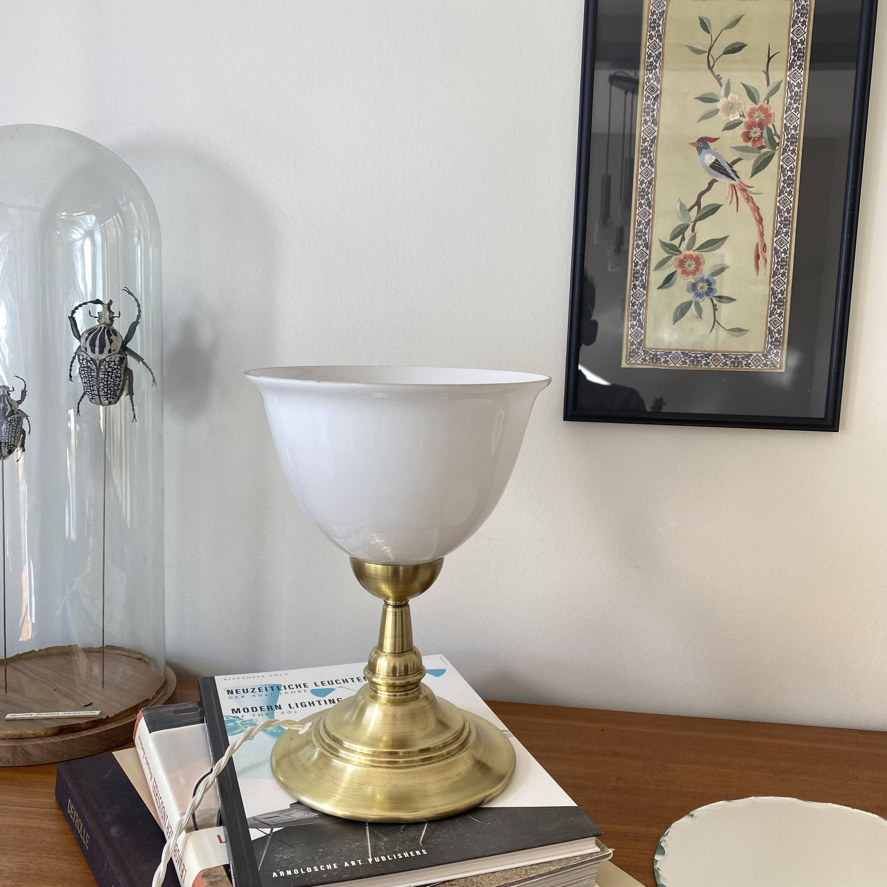 Antique white opaline glass globe table lamp with a brass base.