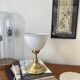 Antique white opaline glass globe table lamp with a brass base.