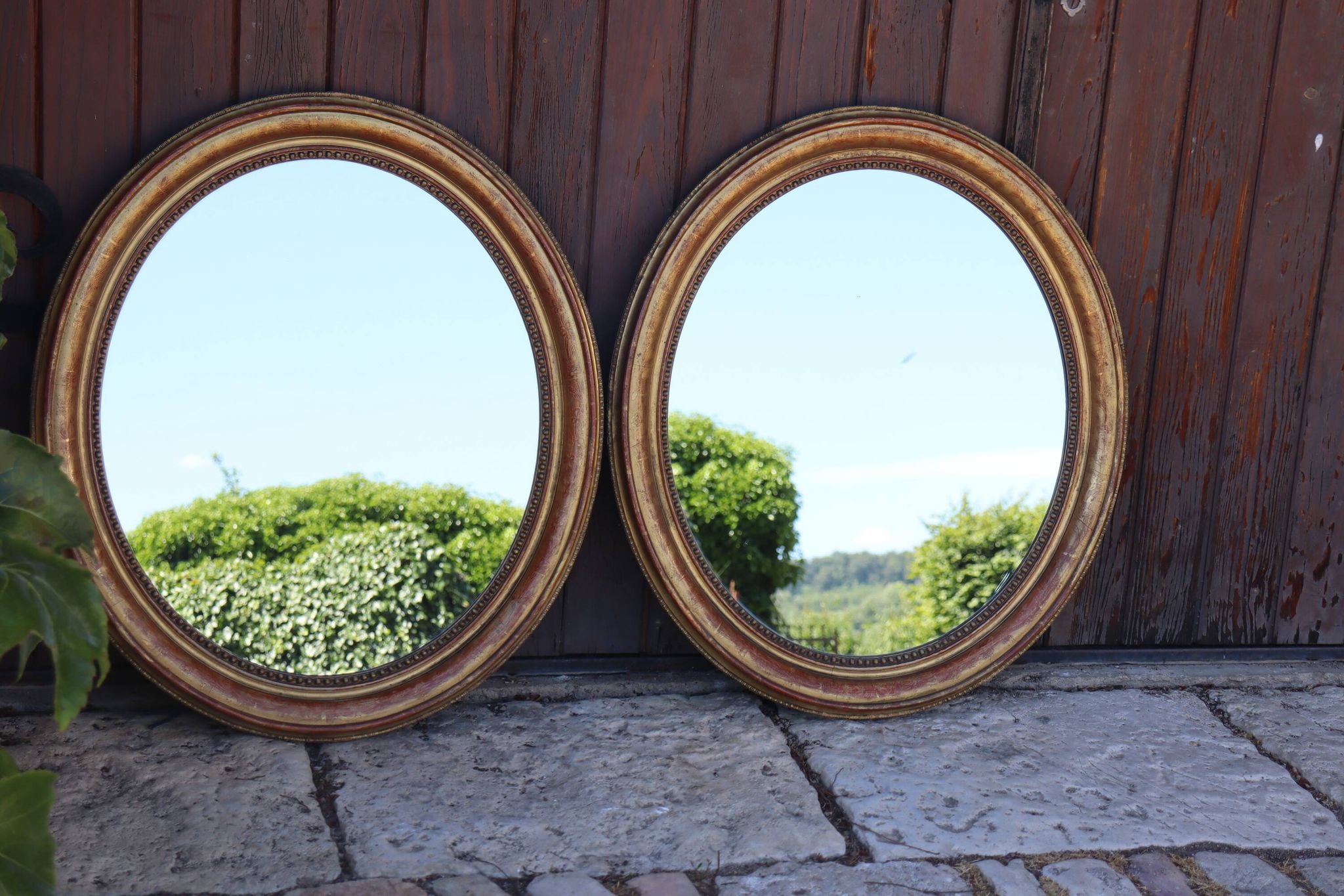 Paire de miroirs ovales en bois doré époque Louis Philippe