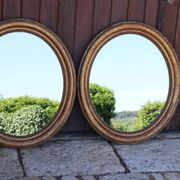 Paire de miroirs ovales en bois doré époque Louis Philippe