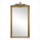 Golden Louis XVI style mirror with bouquet and shells.