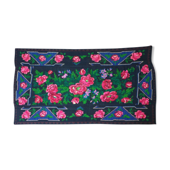 Handwoven floral wool rug, black background with pink roses