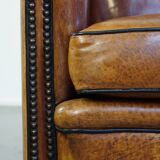Sheep leather design armchair finished with decorative nails and black piping
