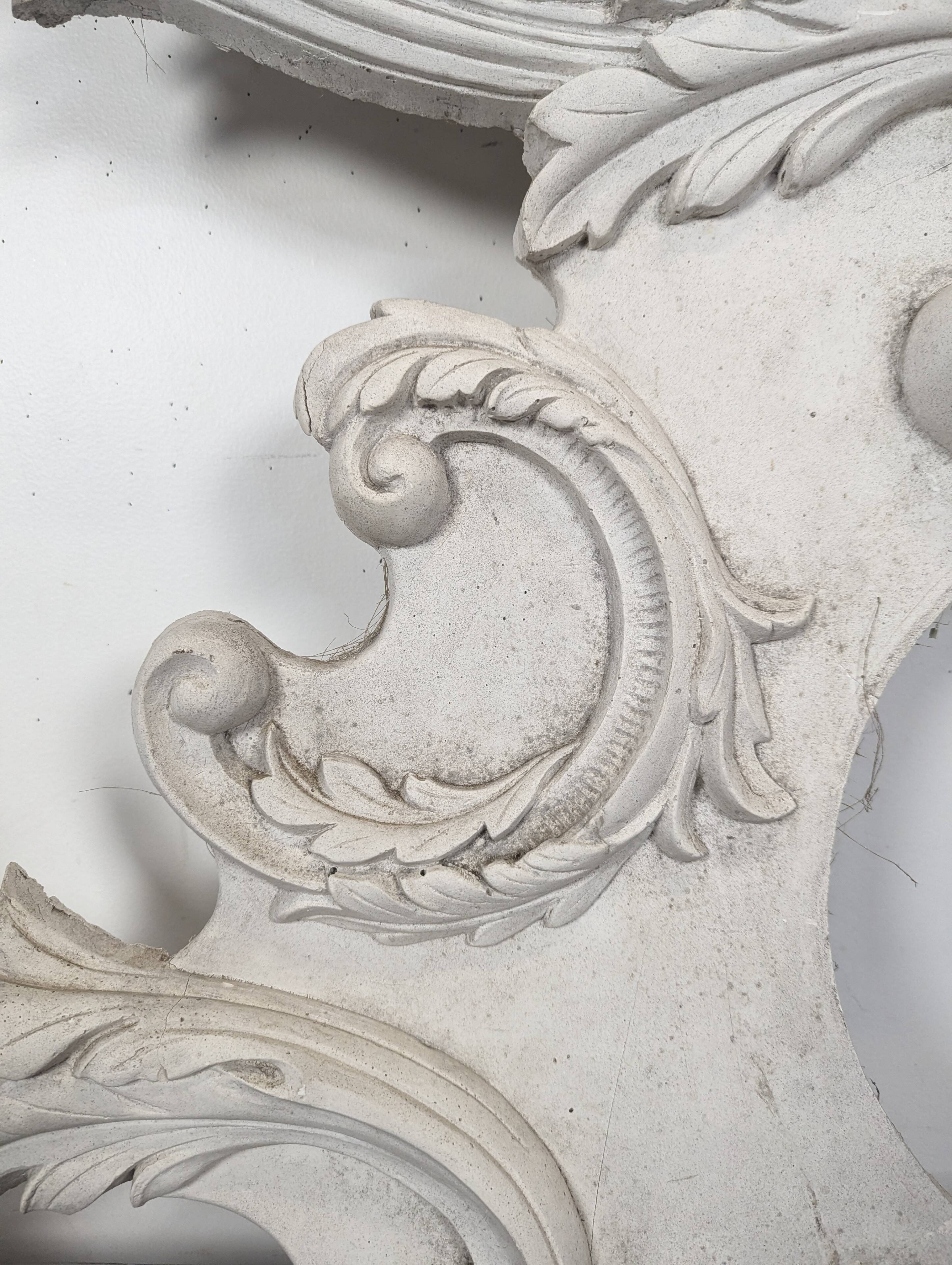 Large rococo fronton in stucco and carved wood, patinated white with an oculus.