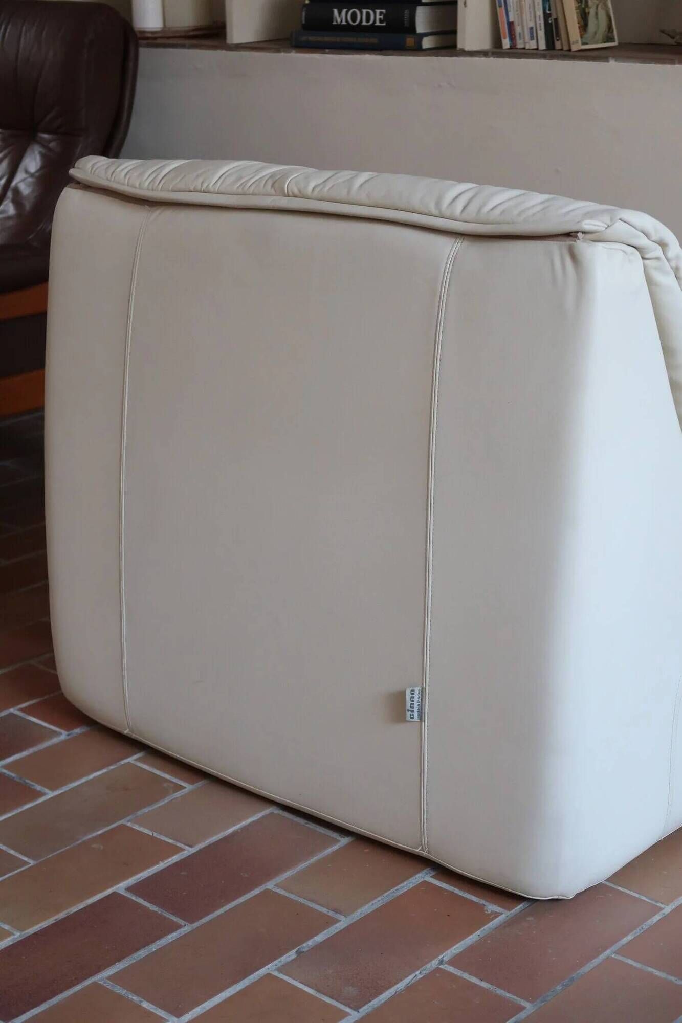 Cinna armchair in cream leather, bolstered armrests, 1970s.