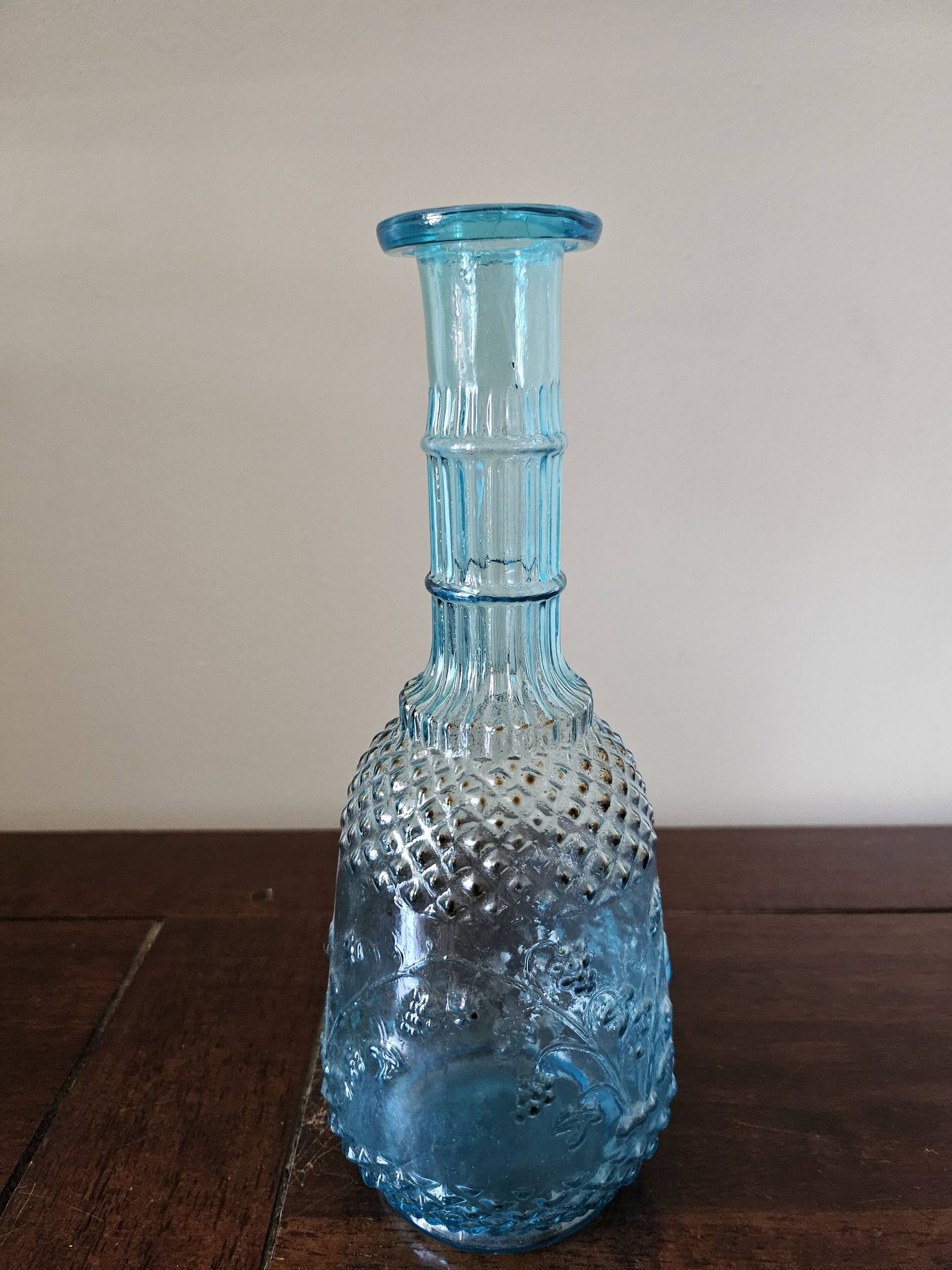 Small vintage turquoise blue glass carafe with floral design.