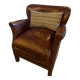 Brown cowhide armchair with a reversible seat cushion in KELIM.