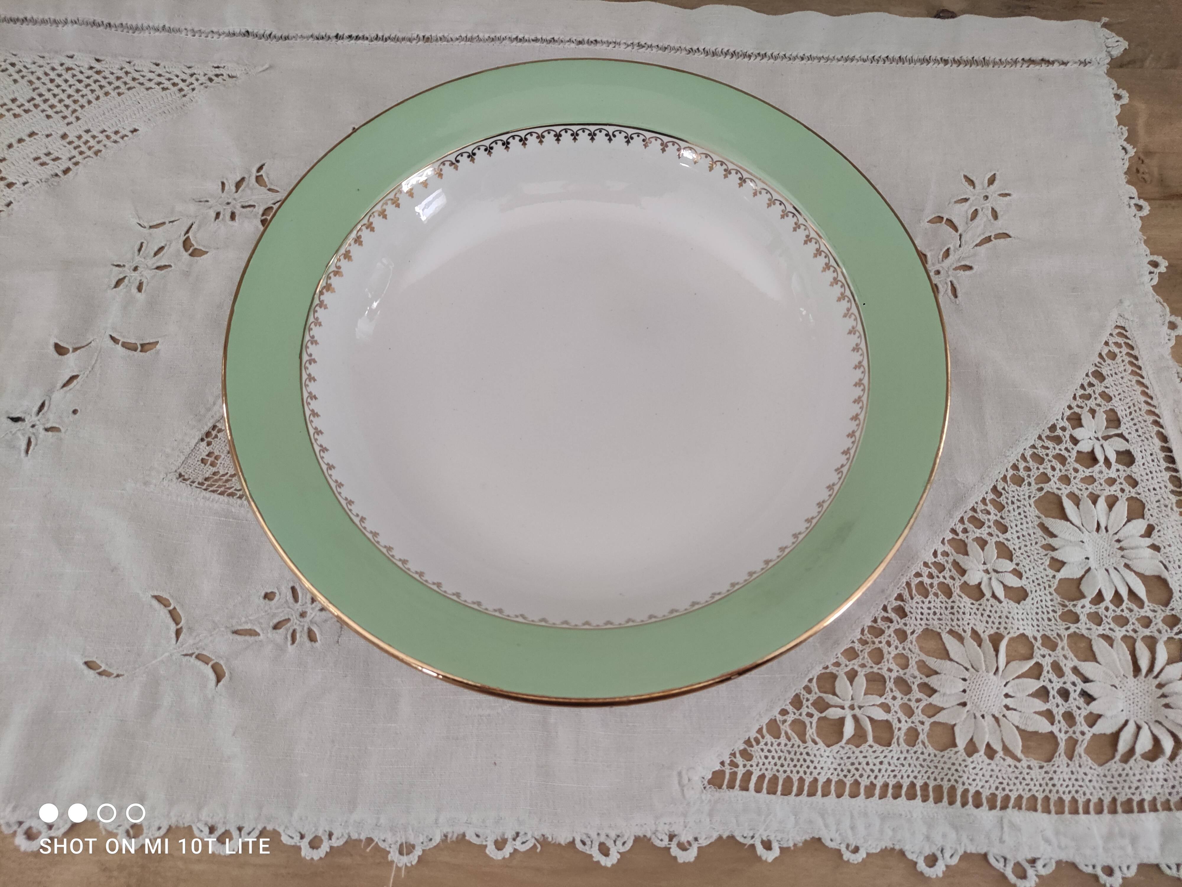 Round hollow plate in water green with a golden frieze, Cafés Lemaire.