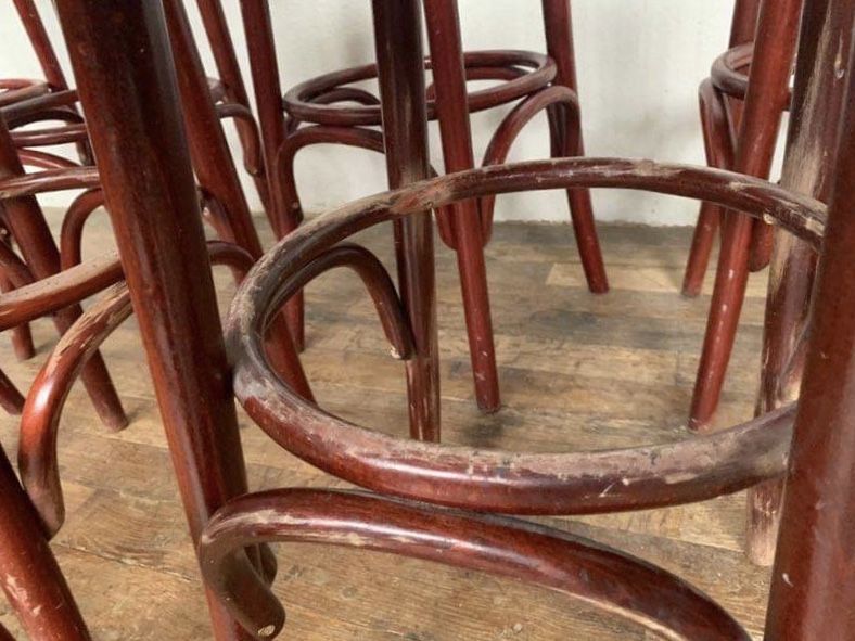 Series of 9 bistro bar stools in curved wooden restaurant sitting red fabric