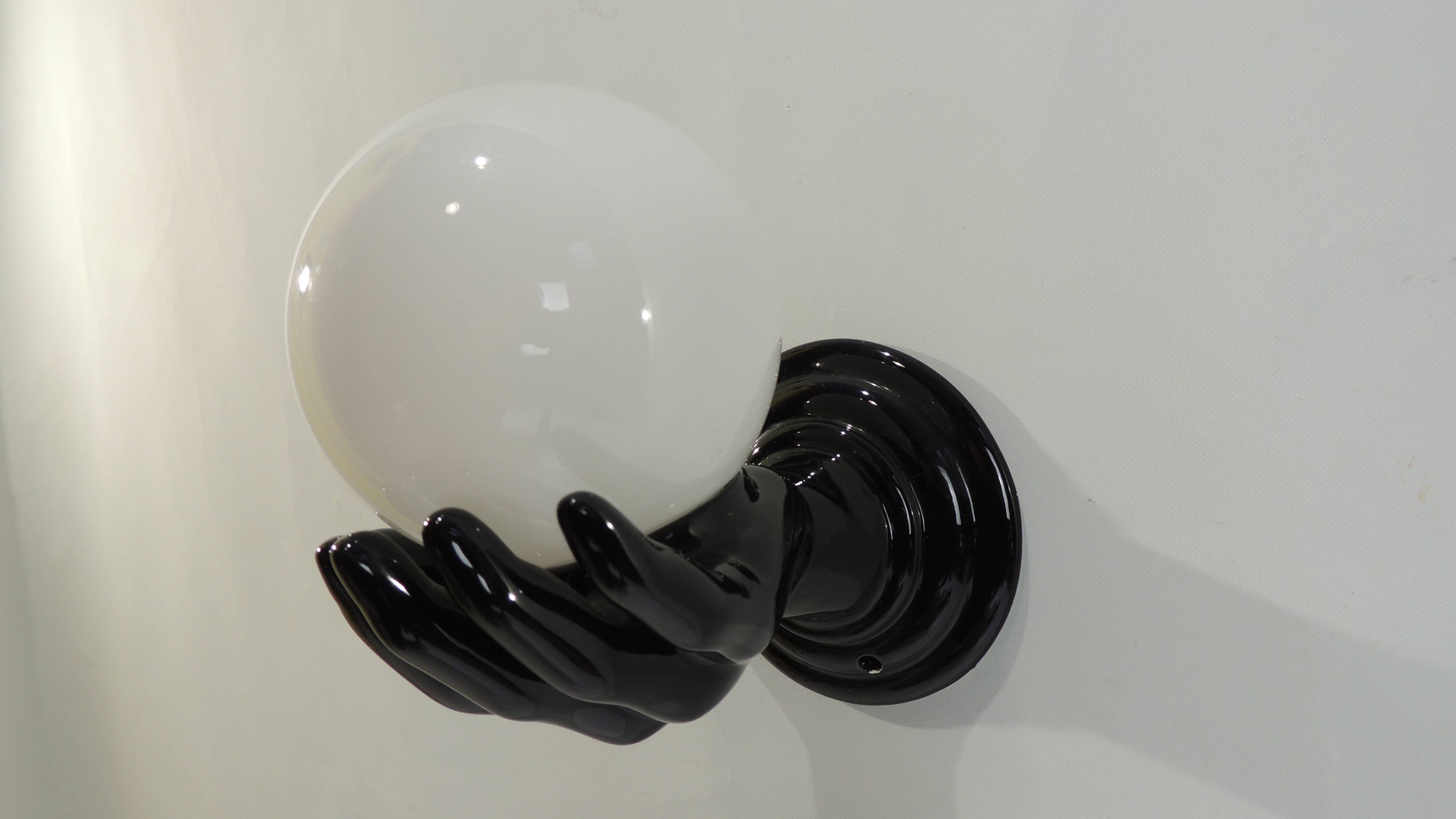 Paire d’appliques mains noires tenant un globe en opaline, années 70