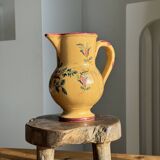 Large antique handmade ochre yellow jug with a pink flower pattern.