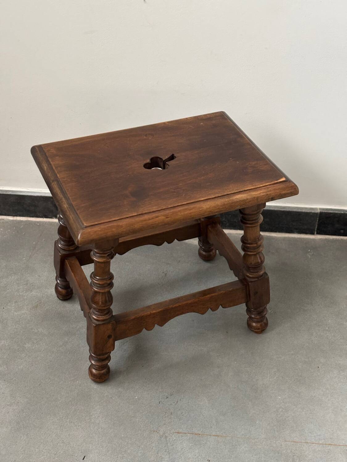Small antique wooden stool with an openwork pattern.