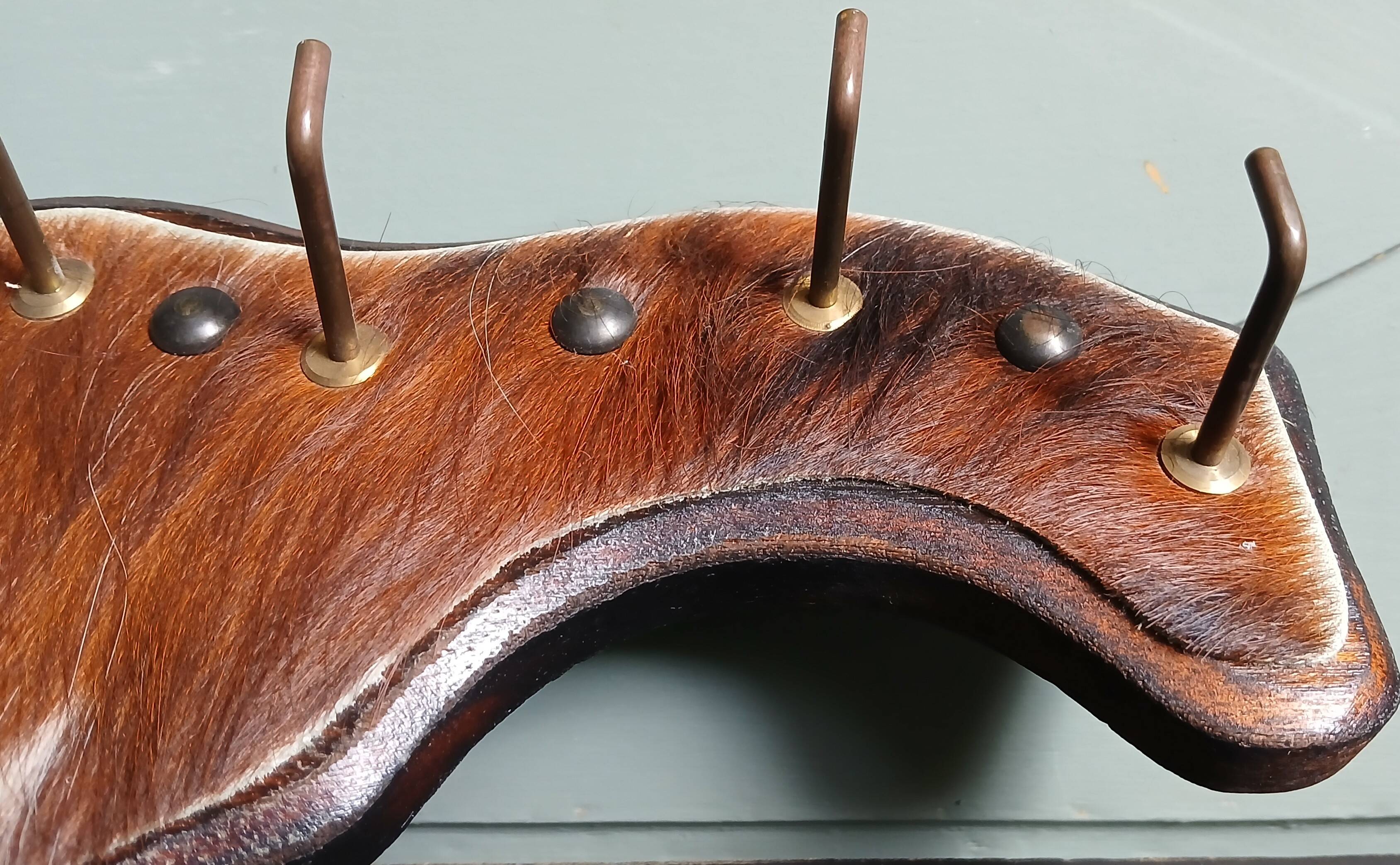 Wooden coat rack, nails & cowhide