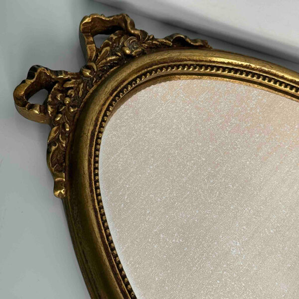 Miroir ovale vintage doré style Louis XVI à décor de rubans et de roses