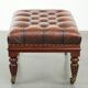 Brown cowhide Chesterfield ottoman in English style with ornate legs