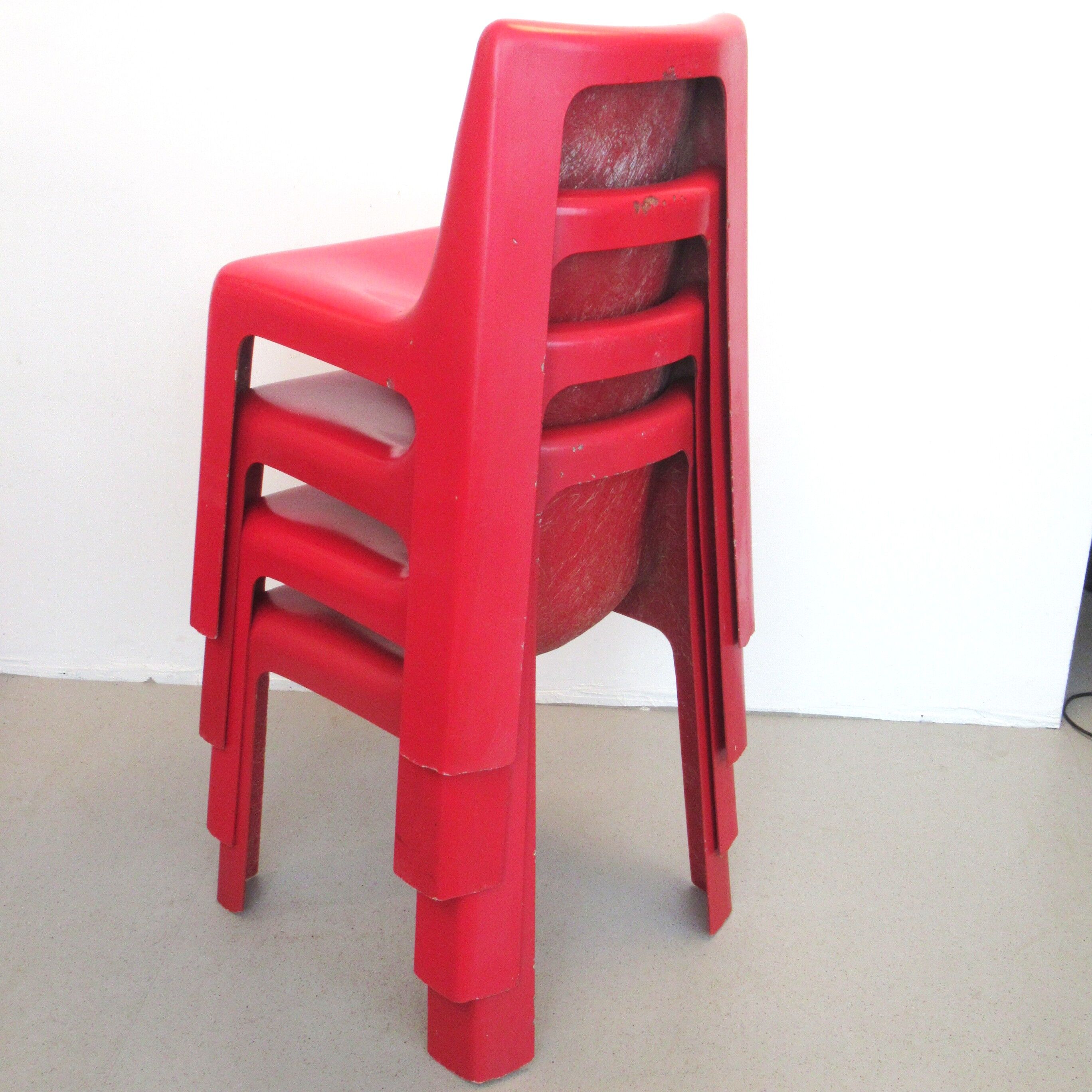 Four red fibreglass chairs from the 1970s.
