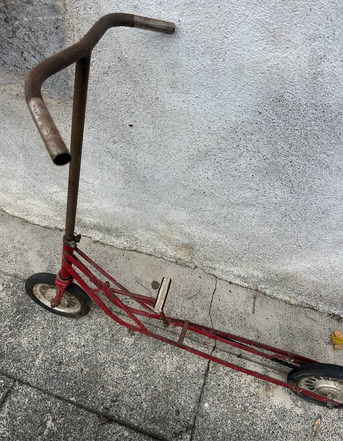 Trottinette rouge ancienne à pédale et chaîne