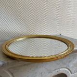 Round mirror with golden wood frame