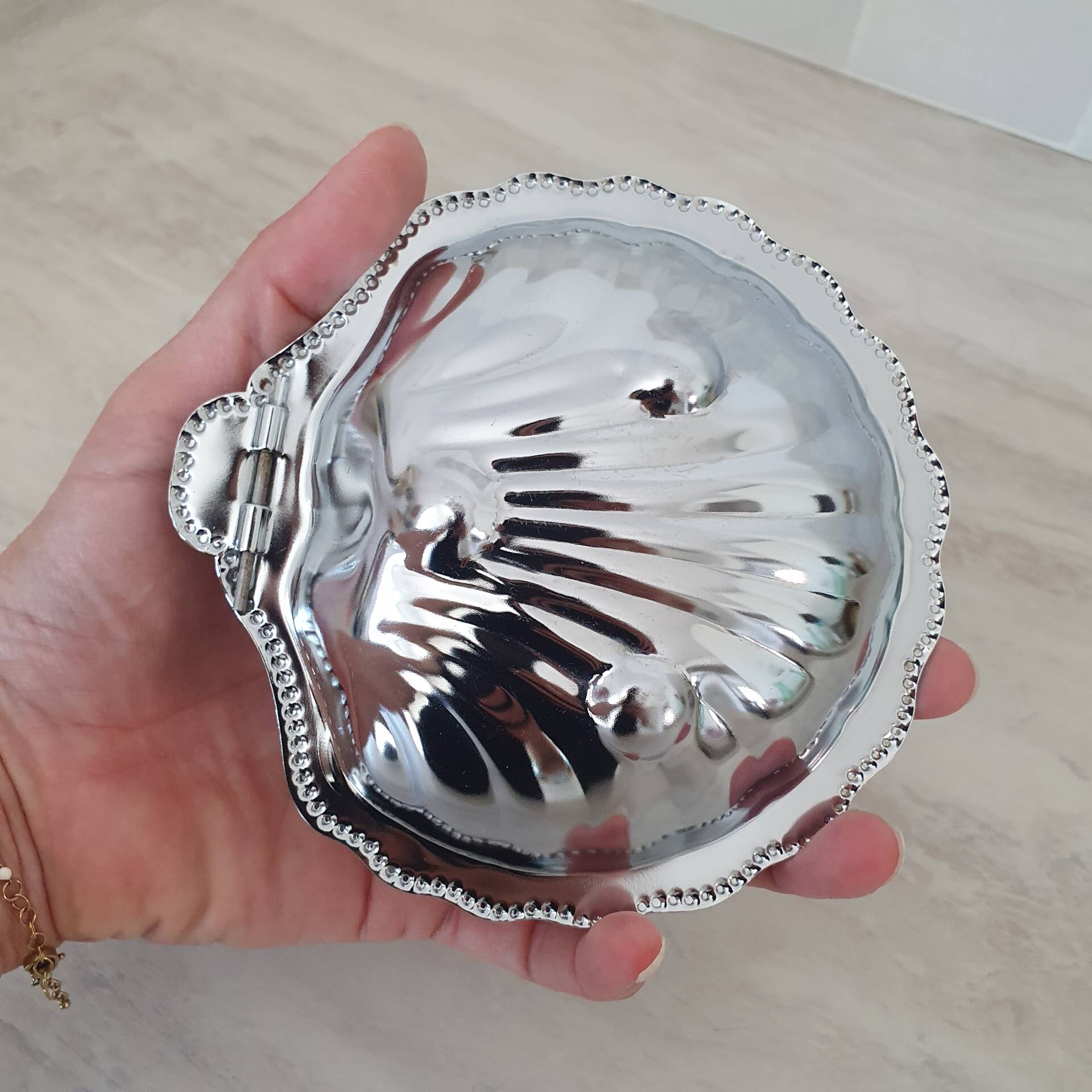 Scallop shell butter dish in stainless steel with its white glass saucer.