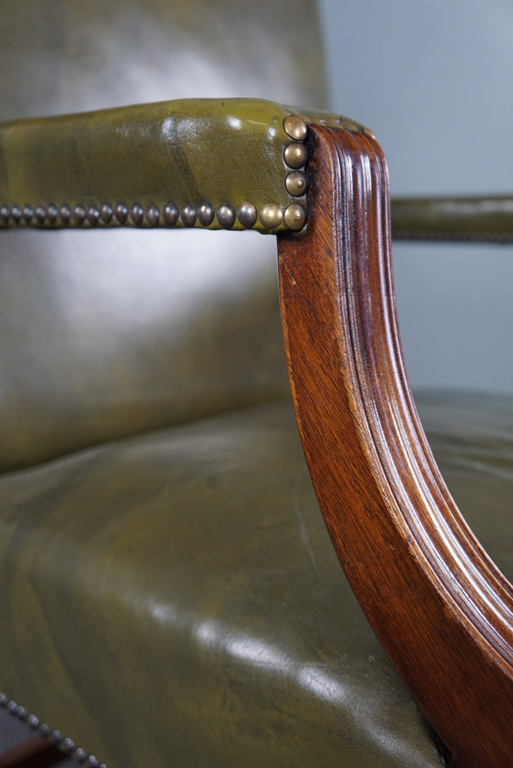 Elegant armchair and footrest in English green leather