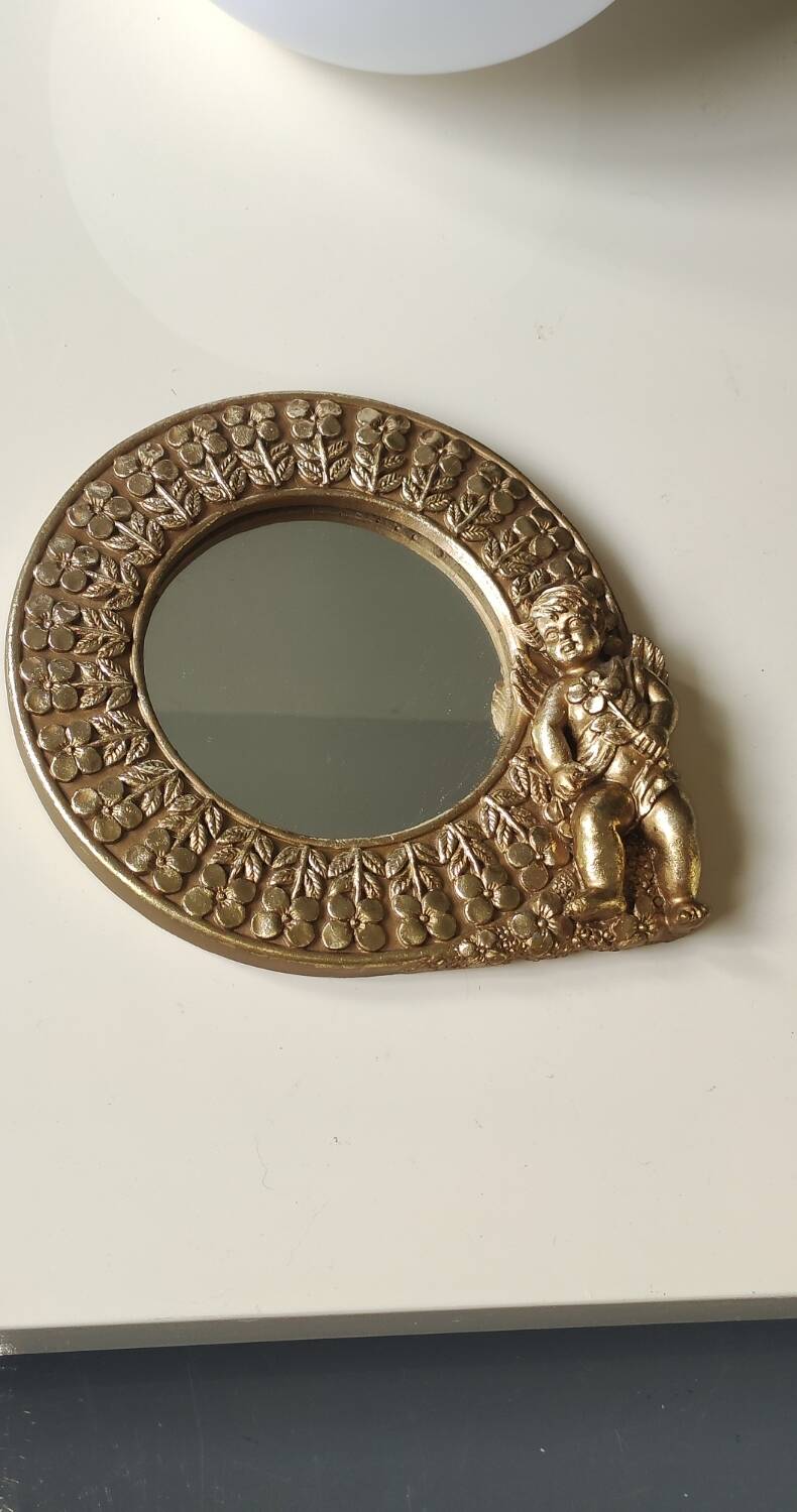 Shabby Chic round mirror. Putti/Cherub decor. Floral motifs. Dimensions: 20 x 20 cm.