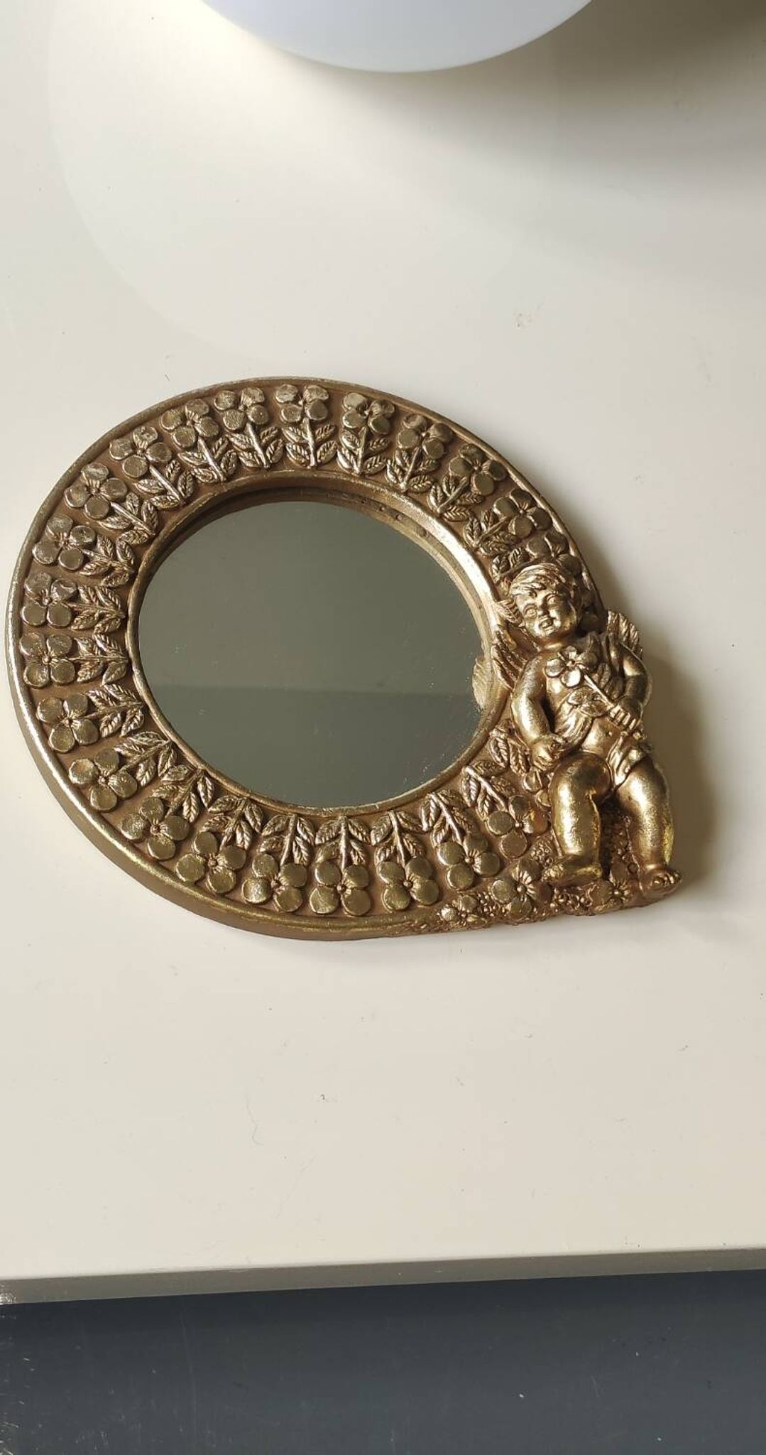 Shabby Chic round mirror. Putti/Cherub decor. Floral motifs. Dimensions: 20 x 20 cm.
