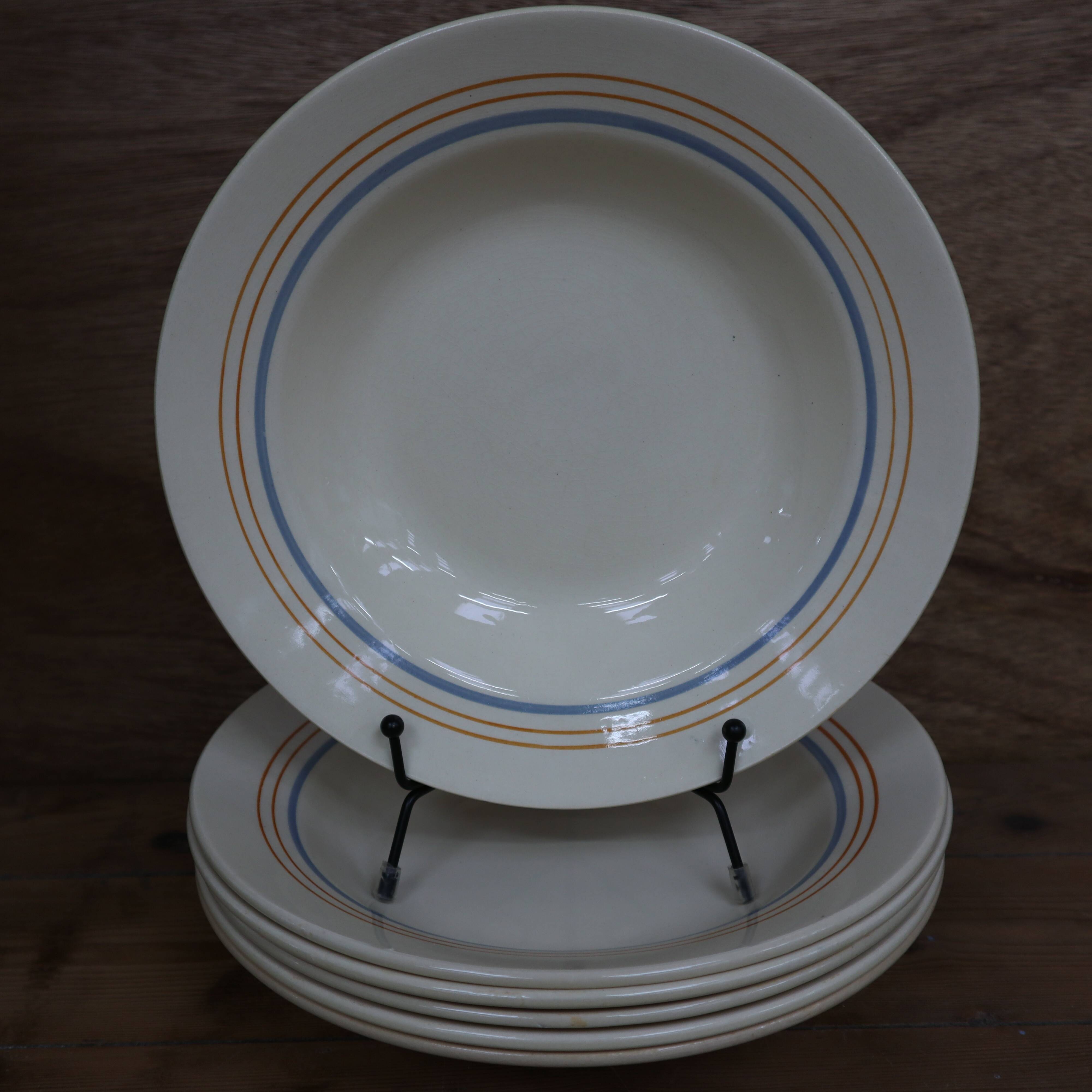 6 old cream-coloured deep plates with blue/orange trim.