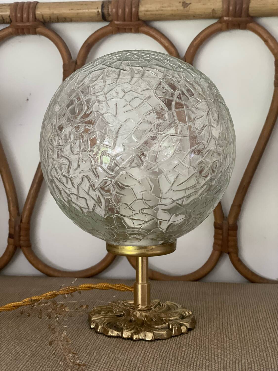Small handcrafted globe lamp with a cracked finish and a golden brass base.